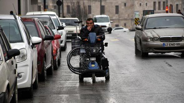 Akülü engelli aracıyla tekerlekli sandalye taşıyor